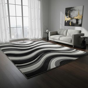 May include: A large rectangular rug featuring a flowing, wavy design in black, grey, and white. The rug sits on a dark wood floor. The pattern creates a sense of movement, adding a modern touch to the room. The rug measures approximately 240cm x 300cm.