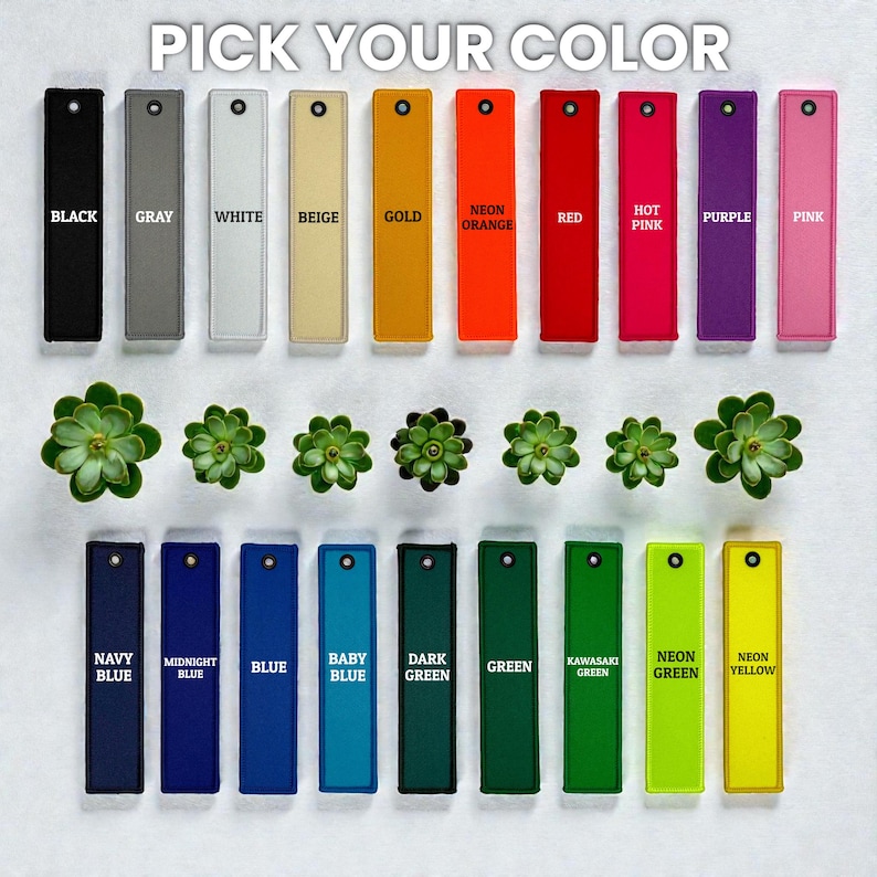 May include: A selection of colorful rectangular tags, each labeled with a different color name, including black, gray, white, and neon yellow. The text "PICK YOUR COLOR" is at the top. Small green succulents are interspersed between the tags.