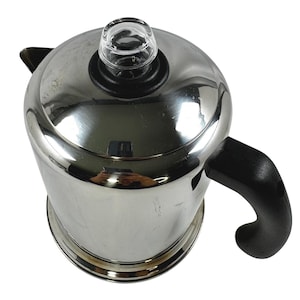May include: Stainless steel coffee percolator with a black handle and a clear glass knob on top. The percolator has a shiny, reflective surface and a rounded shape. The handle is curved for easy gripping.