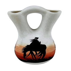 May include: A white ceramic mug with a black handle and the text "But First, Coffee" in a black, bold font. The mug is on a white surface.