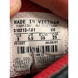 Puede incluir: Primer plano de una etiqueta de zapato con la inscripci&oacute;n "MADE IN VIETNAM". La etiqueta muestra detalles de tallas: US 8, UK 5.5, EUR 39 y 25 cm. Tambi&eacute;n incluye informaci&oacute;n de producci&oacute;n y c&oacute;digo de barras.