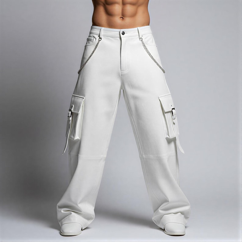 May include: White cargo pants with silver chain detailing and two front pockets with buckles. The pants have a wide leg design and are made of a smooth, solid white material. The pants are shown with white shoes.