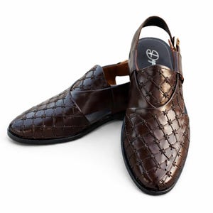 May include: A pair of brown leather sandals with a woven pattern. The sandals have a slingback strap and a pointed toe. The leather is a rich, dark brown color. The soles are black.