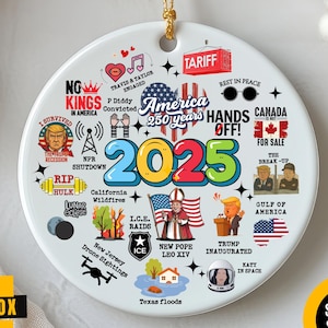 Peut inclure: Ornement de disque en céramique blanche avec une ficelle dorée. Il présente l'année "2025", le texte "America 250 years" et diverses illustrations. L'ornement est posé sur un fond blanc.