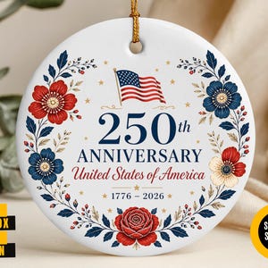 May include: A white ceramic ornament with a gold string, featuring a floral wreath in red and blue around the text "250th Anniversary United States of America 1776-2026" and an American flag.