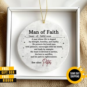 May include: A round, off-white ornament with the text "Man of Faith" and a definition. The ornament is in a white box with a gold string for hanging. Includes the name "Peter".