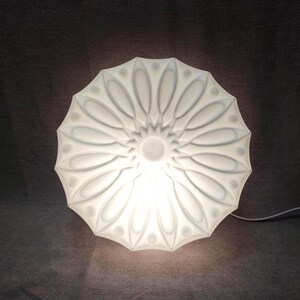 Luminária de parede vintage floral branca, estilo meados do século XX, com design de raio de sol e acabamento em vidro leitoso.