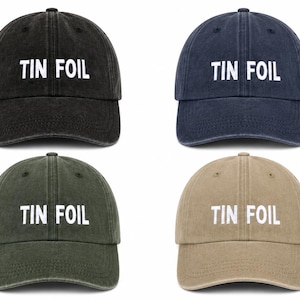 Könnte beinhalten: Vier Baseballkappen in Schwarz, Marineblau, Olivgrün und Beige. Jede Kappe hat den weißen Schriftzug "TIN FOIL". Ein klassisches, lässiges Accessoire.