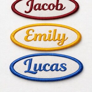 K&ouml;nnte beinhalten: Drei gestickte Namensaufn&auml;her: "Jacob" in Burgunderrot, "Emily" in Gold und "Lucas" in Blau. Jeder Name ist in Schreibschrift auf wei&szlig;em Hintergrund und von einem passenden ovalen Rand umgeben.