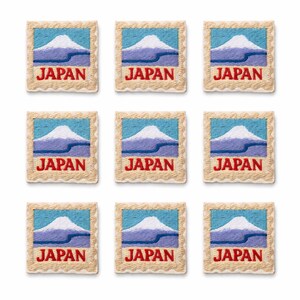 May include: Nine embroidered patches featuring a design of a mountain with a blue sky background. The word "JAPAN" is in red letters at the bottom of each patch. The patches have a cream-colored, scalloped border.