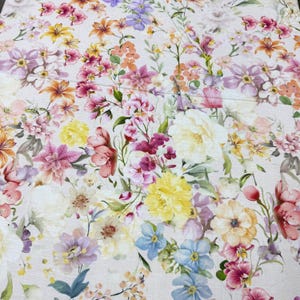 May include: A fabric with a vibrant floral pattern. The design features a variety of flowers in shades of pink, yellow, orange, purple, and blue, set against a light background. The flowers are detailed and realistic, creating a colorful and lively textile.