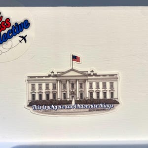 May include: A sticker depicting the White House with an American flag. The text "This is why we can't have nice things" is below the building. A logo with the text "Jett Press Collective" is in the upper left corner.
