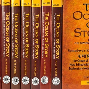 May include: A collection of hardcover books titled "The Ocean of Story," with volumes numbered I through X. The spines are a deep brown with gold lettering. The cover of Vol. I is a warm orange with the title in large, bold letters.