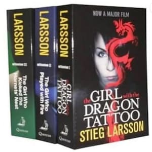 Pode incluir: Um conjunto de três livros de Stieg Larsson. Os títulos incluem "Os Homens que Odeiam as Mulheres", "A Rapariga que Sonhava com uma Lata de Gasolina e um Fósforo" e "A Rainha no Palácio das Correntes de Ar". A capa de "Os Homens que Odeiam as Mulheres" apresenta o rosto de uma mulher com um desenho de dragão vermelho.