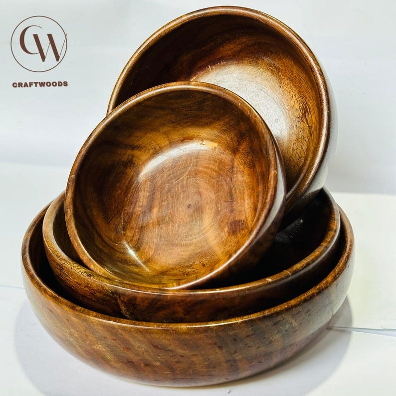 May include: A stack of four wooden bowls in varying sizes. The bowls are made of a dark brown wood with visible grain patterns. The Craftwoods logo is in the upper left corner.