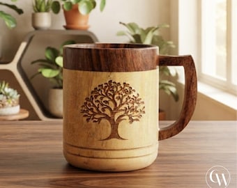 Può includere: Una tazza cilindrica in legno dal design bicolore, con bordo e manico marrone scuro e corpo color beige chiaro. La parte anteriore della tazza presenta un'illustrazione dettagliata incisa al laser di un albero con rami estesi.