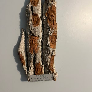 Faces hand carved people in bark carving