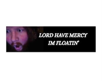 Puede incluir: Una pegatina rectangular con fondo negro y texto blanco que dice "LORD HAVE MERCY IM FLOATIN'". El lado izquierdo de la pegatina presenta un primer plano del rostro de una persona con expresión de sorpresa.
