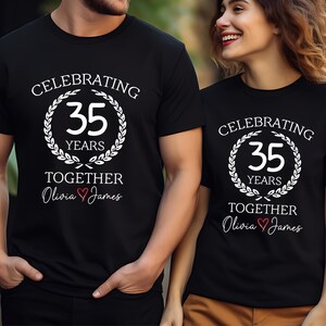 May include: Black t-shirts with white text celebrating a 35th anniversary. The design includes a laurel wreath around the number 35 and the words "Celebrating 35 Years Together" with names below.