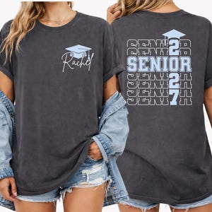 Custom graduation shirt designed with repeating senior text graphics, graduation cap artwork and personalized student name detail printed on a relaxed fit Comfort Colors tee for senior year activities.