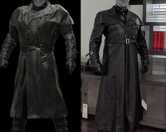 May include: A dark, full-length costume featuring a black trench coat, hat, gloves, and boots. The coat has a double-breasted design with a belt. The character's face is pale, and the costume is likely for cosplay or Halloween.