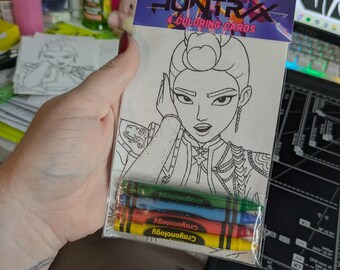May include: A clear plastic package containing four coloring cards and four crayons. The coloring cards feature a black and white illustration of a woman. The package is labeled "HUNTRAX 4 COLORING CARDS". The crayons are green, blue, red, and yellow.