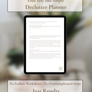 Op de afbeelding: Een zwarte tablet toont de tekst "Your easy and simple Declutter Planner". Het scherm toont tekst over opruimen. Daaronder staat "No Endless Worksheets, No Overcomplicated Steps, Just Results."