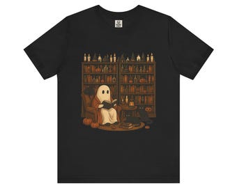 May include: Black t-shirt featuring a whimsical illustration of a ghost reading in a cozy library setting. The design includes a ghost in a robe, a black cat, pumpkins, and a bookshelf filled with books and candles. A perfect Halloween-themed tee.