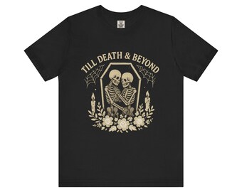 May include: Black t-shirt with a graphic featuring two skeletons embracing inside a coffin, surrounded by flowers and candles. The text "TILL DEATH & BEYOND" is arched above the coffin.