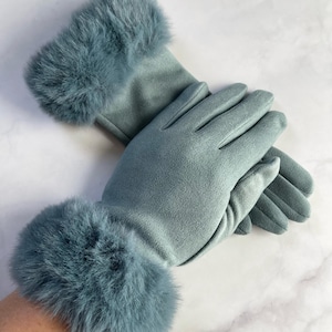May include: Teal gloves with faux fur cuffs. The gloves are made of a soft material and have a classic design. The faux fur trim adds a touch of elegance. The gloves are a stylish accessory for cold weather, suitable for various occasions.