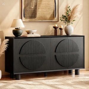 May include: A black wooden sideboard featuring four doors with prominent circular, vertically-ribbed panels. The rectangular cabinet stands on cylindrical legs and is topped with a lamp, a bowl, books, two candle holders, and a vase with dried plants.
