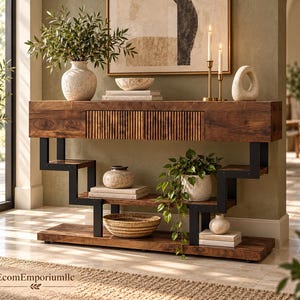 May include: A wooden console table with a slatted drawer front and a black metal frame featuring a stepped, geometric design. The table has a lower shelf and is decorated with various ceramic vases, books, candles, and a woven basket.
