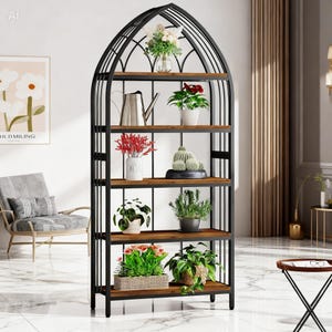 May include: A black metal and wood bookshelf with an arched top. The shelves display various potted plants, flowers, and decorative items. The shelves are made of dark wood. The frame is black.