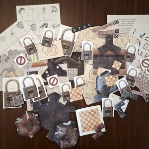 May include: A collection of paper ephemera, including lock illustrations, diagrams, and text fragments, arranged on a dark wooden surface. The items feature various symbols, text, and a chess board. The word "ALCHEMY" is visible.