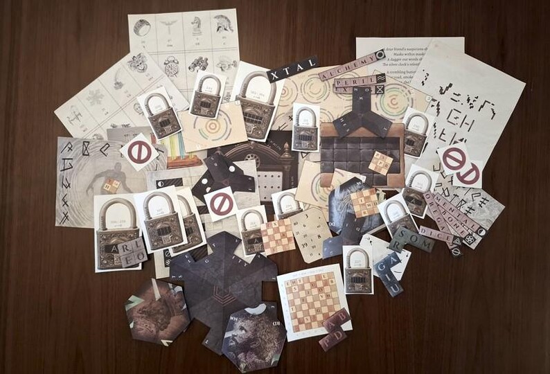 May include: A collection of paper ephemera, including lock illustrations, diagrams, and text fragments, arranged on a dark wooden surface. The items feature various symbols, text, and a chess board. The word "ALCHEMY" is visible.