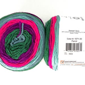 May include: Two skeins of Premier Yarns acrylic yarn in the "Parrot" colorway. The yarn is a mix of green, teal, pink, and purple. The label includes the color number, barcode, and brand information.