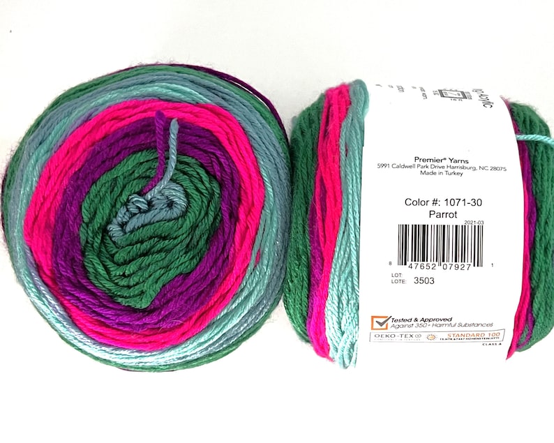 May include: Two skeins of Premier Yarns acrylic yarn in the "Parrot" colorway. The yarn is a mix of green, teal, pink, and purple. The label includes the color number, barcode, and brand information.