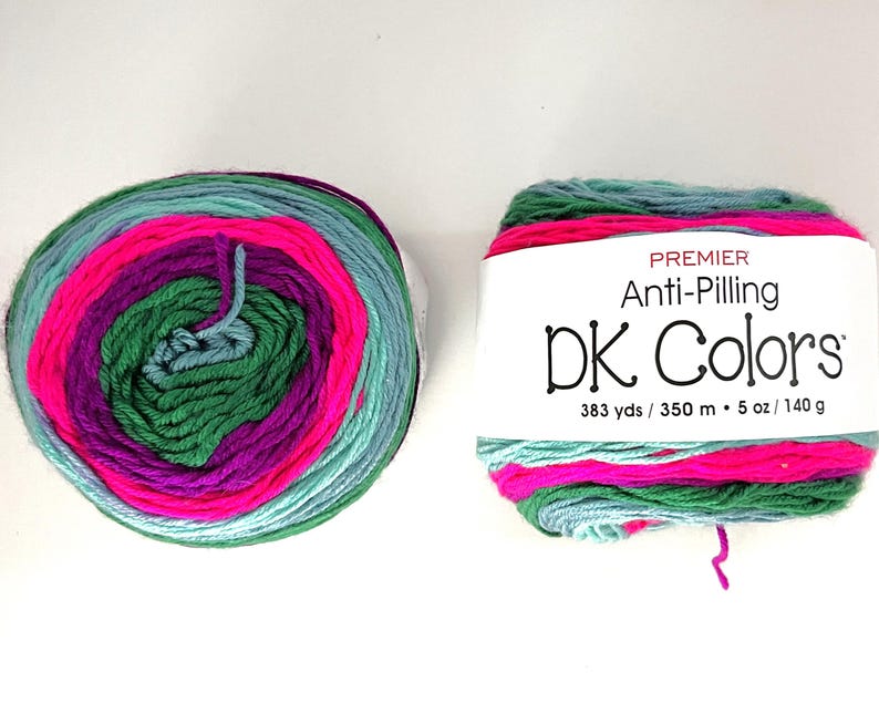 May include: Two skeins of Premier DK Colors yarn. The yarn is multi-colored with bands of pink, purple, green, and teal. The label reads "Premier Anti-Pilling DK Colors" and indicates 383 yards / 5 oz / 140 g.