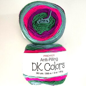 May include: Two skeins of Premier Anti-Pilling DK Colors yarn. The yarn is a mix of colors including teal, pink, purple, and green. The label reads "DK Colors" and lists the yardage and weight as 383 yds / 5 oz / 140 g.