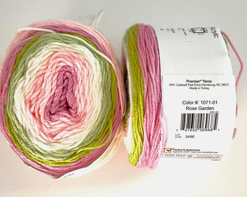 May include: Two skeins of Premier Yarns acrylic yarn in the Rose Garden colorway. The yarn is a blend of pink, white, and green. The label indicates the color number, manufacturer, and that it is made in Turkey.