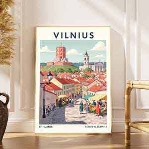 Puede incluir: Una impresión artística enmarcada con una colorida ilustración de Vilna, Lituania. La obra representa un paisaje urbano con una ciudad de tejados rojos, un castillo en una colina y el texto "VILNIUS" en la parte superior. La impresión incluye el texto "LITHUANIA" y coordenadas.