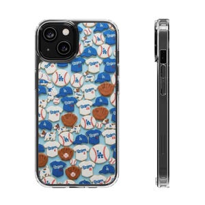 Könnte beinhalten: Transparente Handyhülle mit einem Muster aus Baseball-Keksen, darunter Trikots, Mützen, Handschuhe und Basebälle. Die Kekse sind in Blau, Weiß und Braun mit dem Dodgers-Logo verziert. Die Hülle hat einen transparenten Rand.