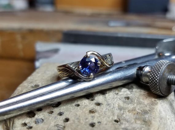 Gold custom Mokume Gane Solitaire engagement Ring custom handmade shown with Montana Sapphire