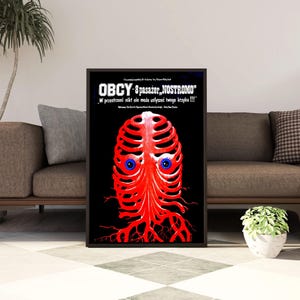Puede incluir: Póster de película polaco enmarcado para "Alien" (OBCY-8 pasażer, NOSTROMO). El póster presenta una criatura roja con forma de esqueleto y ojos azules sobre un fondo negro. También se ve el texto "W przestrzeni nikt nie może usłyszeć twego krzyku !!!".