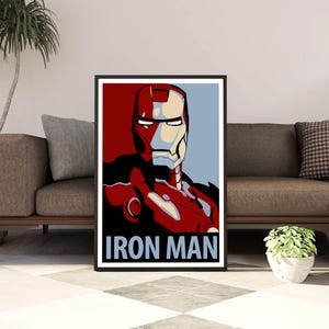 Könnte beinhalten: Ein rechteckiger Wandkunstdruck mit einer stilisierten grafischen Illustration der Figur Iron Man in Rot-, Gold- und Hellblautönen. Die Figur ist ab der Brust aufwärts dargestellt und der Text IRON MAN ist in fetten blauen Buchstaben gedruckt.