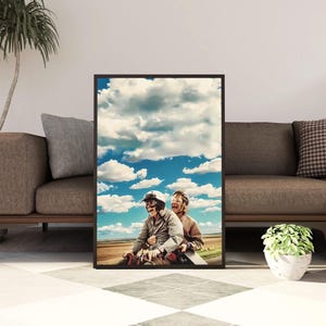 Puede incluir: Una impresión de arte mural vertical enmarcada que muestra a dos personas con cascos y gafas protectoras montadas en una motocicleta. Se ríen con la boca abierta bajo un cielo azul brillante lleno de nubes blancas y un paisaje marrón borroso.
