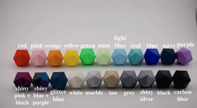 Puede incluir: Una colecci&oacute;n de cuentas geom&eacute;tricas de colores, incluyendo rojo, rosa, naranja, amarillo, verde, azul y morado. La imagen tambi&eacute;n incluye cuentas con acabados brillantes y de m&aacute;rmol. Etiquetas de texto identifican cada color.