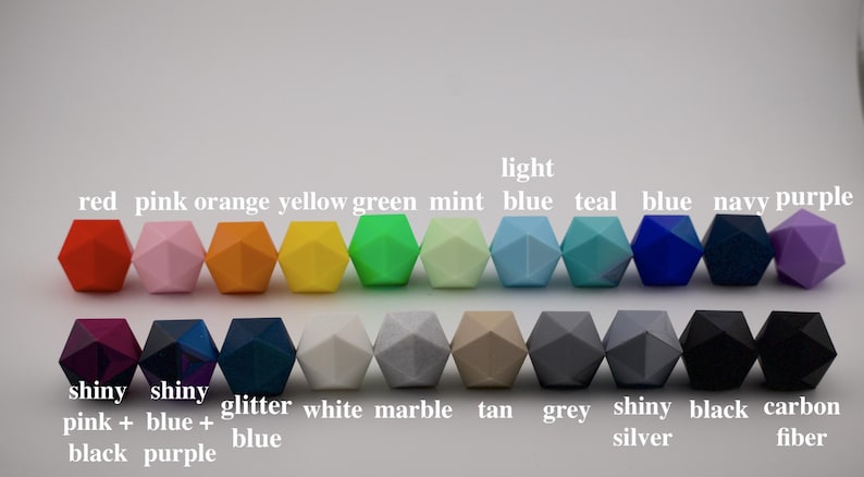 K&ouml;nnte beinhalten: Eine Sammlung farbenfroher, geometrisch geformter Perlen in verschiedenen Farben, darunter Rot, Rosa, Orange, Gelb, Gr&uuml;n, Mint, Hellblau, T&uuml;rkis, Dunkelblau, Marine und Lila. Weitere Perlen sind gl&auml;nzend pink + schwarz, gl&auml;nzend blau + lila, Glitzerblau, Wei&szlig;, Marmor, Beige, Grau, gl&auml;nzend Silber, Schwarz und Kohlefaser.