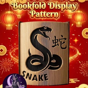 Op de afbeelding: Een boekvouwpatroon met een zwart slangontwerp en het woord "SNAKE" eronder, plus Chinese karakters. De achtergrond is rood met gouden accenten, lantaarns en wolken. De tekst "Bookfold Display Pattern" staat bovenaan.