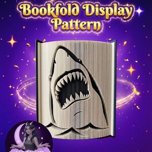 May include: A bookfold display pattern with a shark design carved into the pages. The shark's open mouth shows its teeth. The text "Bookfold Display Pattern" is above the book. The background is purple with stars and confetti.